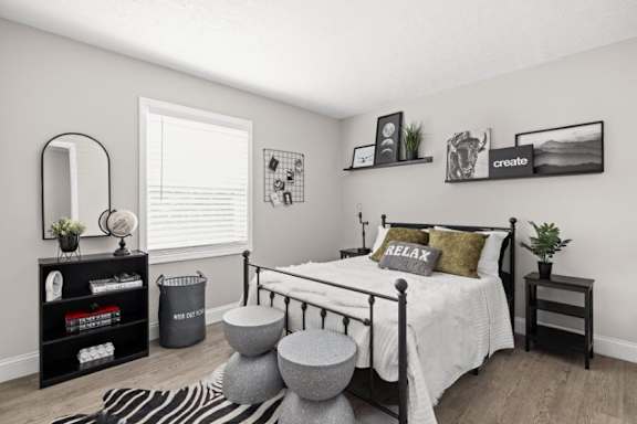 A bedroom with a bed, nightstand, and a mirror.