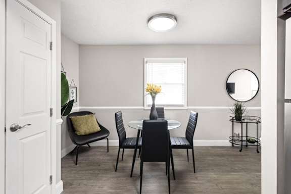 A dining room with a table set for four.