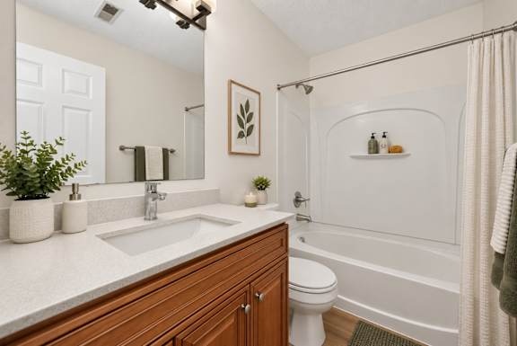 A bathroom with a white tub, sink, and toilet.