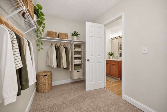 A white door is open to a room with a white wall and a wooden floor.
