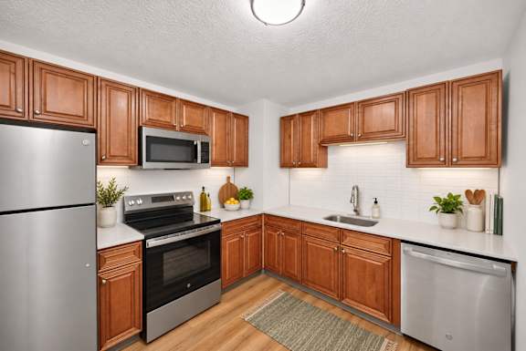 A kitchen with wooden cabinets and a stainless steel refrigerator.