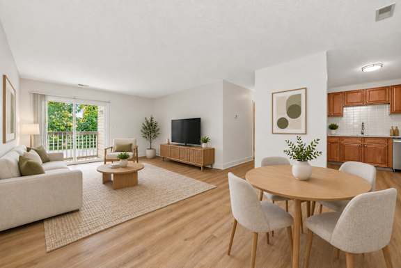 A living room with a couch, chairs, and a television.