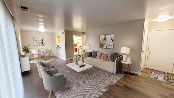 A modern living room with a grey sofa, a coffee table, and a grey armchair.