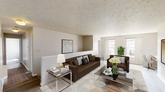 A modern living room with a brown couch and a glass coffee table.
