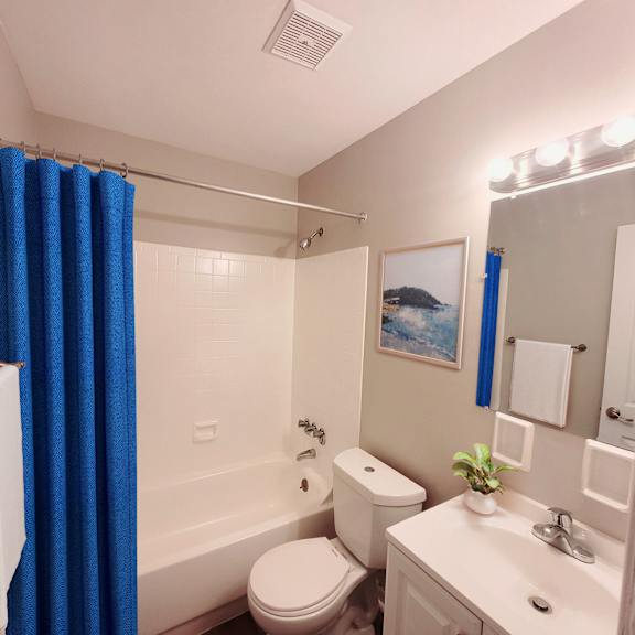 A white toilet sits next to a white sink in a bathroom.