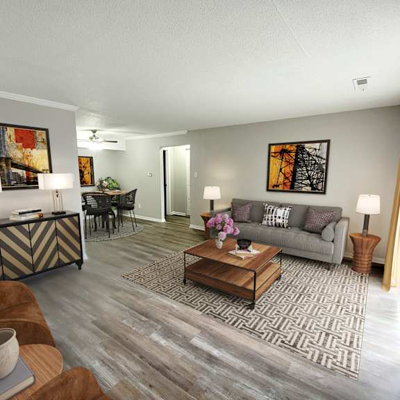 A living room with a grey couch, a coffee table, and a painting on the wall.