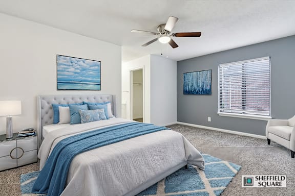 A bedroom with a large bed and a ceiling fan.