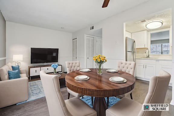 A modern dining room with a wooden table and white chairs.