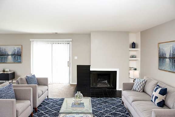 A living room with a fireplace and two couches.