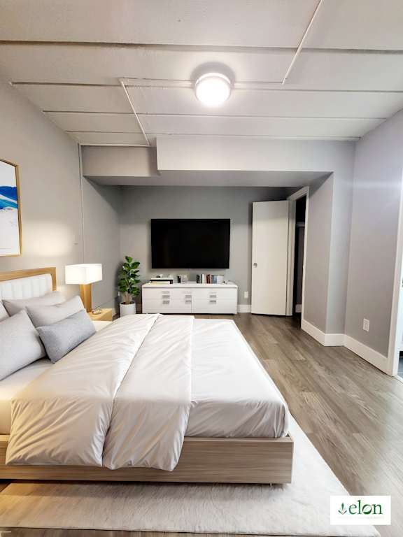 A bedroom with a large bed and a flat screen TV.
