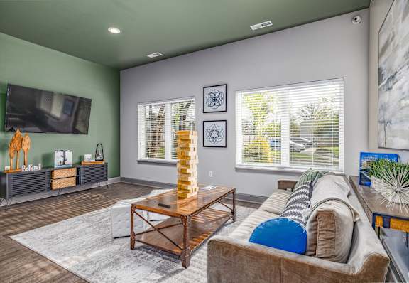 A living room with a couch, a coffee table, and a television.