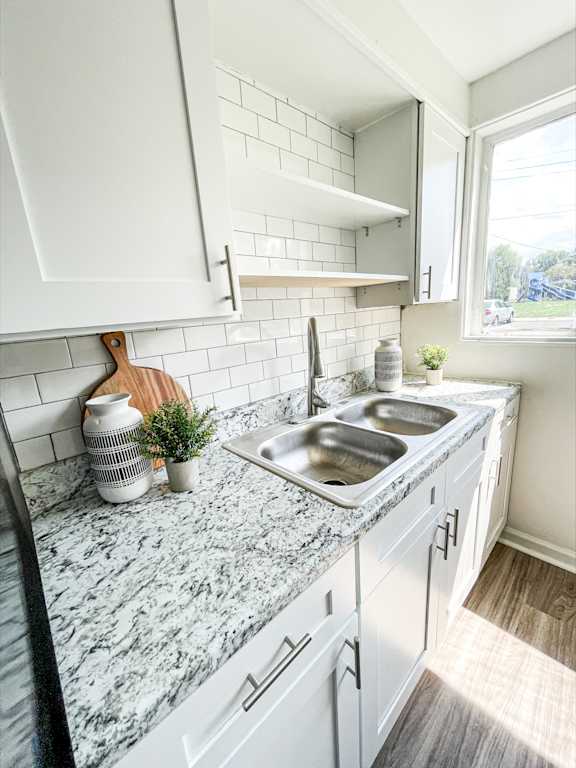 A kitchen with a marble countertop and white cabinets.