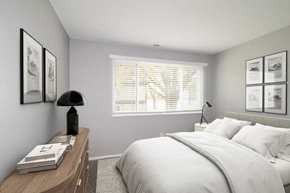 A bedroom with a bed, nightstand, and pictures on the wall.