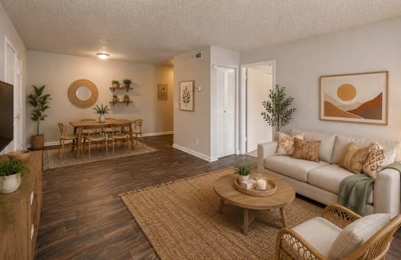 A living room with a white couch, wooden coffee table, and a rug.