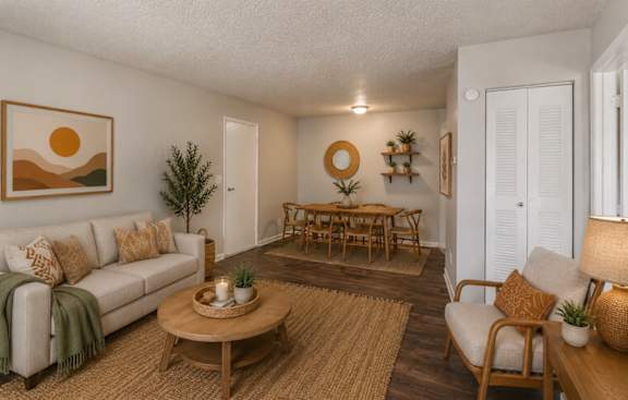 A living room with a white couch, a wooden coffee table, and a painting on the wall.