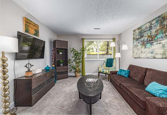 A living room with a brown couch and a black coffee table.