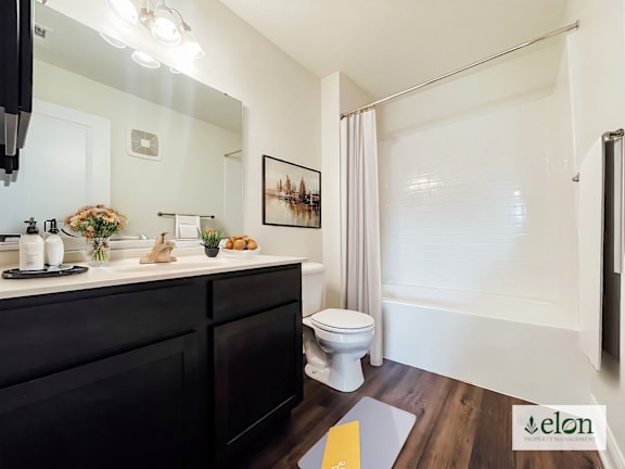 A bathroom with a toilet, sink, and mirror.