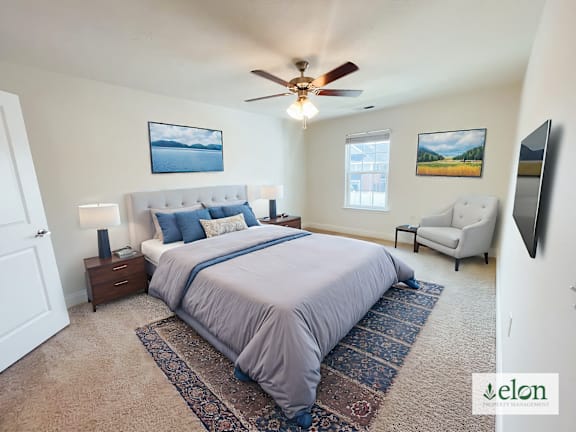 A bedroom with a large bed and a ceiling fan.