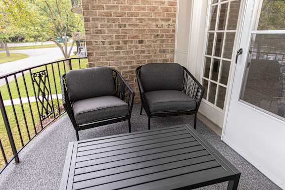 Two black chairs on a porch at The Brittany Apartments, Maryland