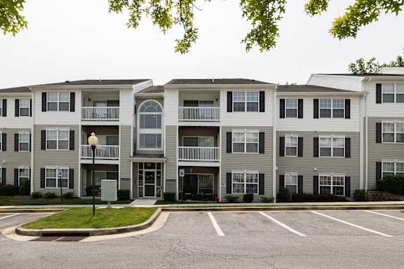 Apartment building with a parking lot in front.