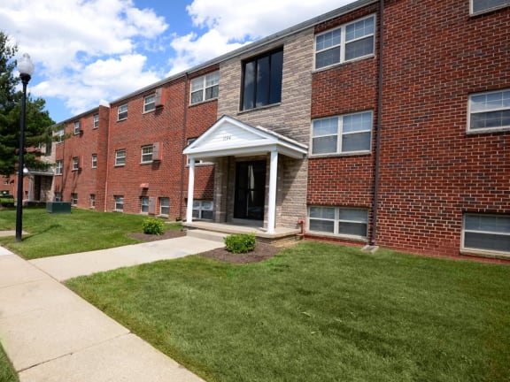 Brick building with a lawn in front of it at Hyde Park Apartments*, Essex, MD 21221