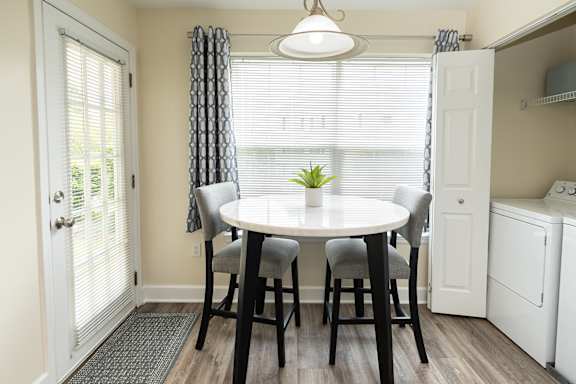 A dining room with a round table and chairs.