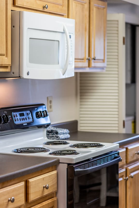 a kitchen with a stove top oven next to a microwave at Chapel Valley Townhomes, Maryland, 21236