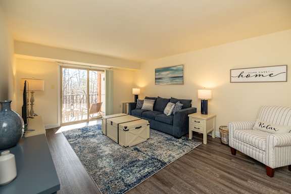 A living room with a sofa, a chair, and a rug  at Liberty Gardens Apartments, Baltimore Maryland