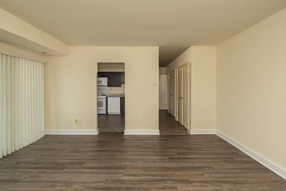 A room with wooden floors and a kitchen area in the background at Lawyers Hill Apartments, Elkridge, MD, 21075
