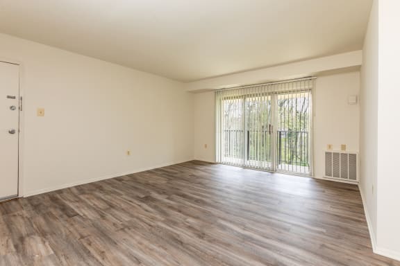 a bedroom with hardwood flooring and a door leading to a balcony at Seminary Roundtop Apartments, Lutherville, Maryland