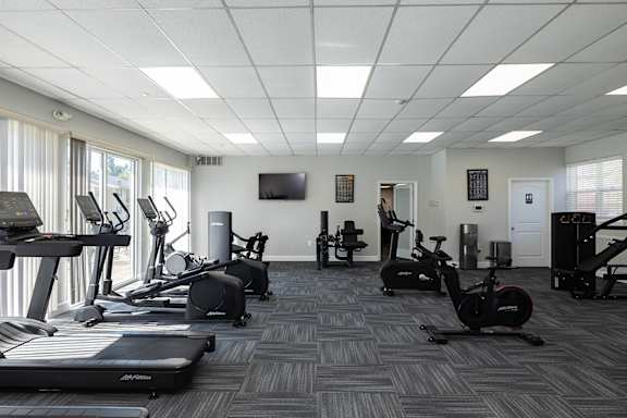 A spacious gym with treadmills, exercise bikes, and other equipment.
