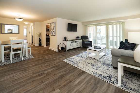 A living room with a grey couch and a wooden floor.