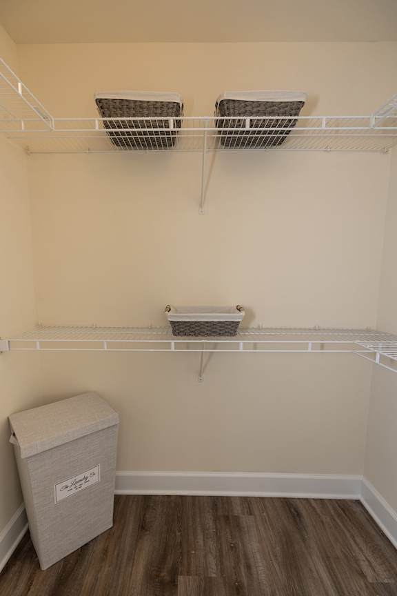 A white shelf with two baskets and a box on it.