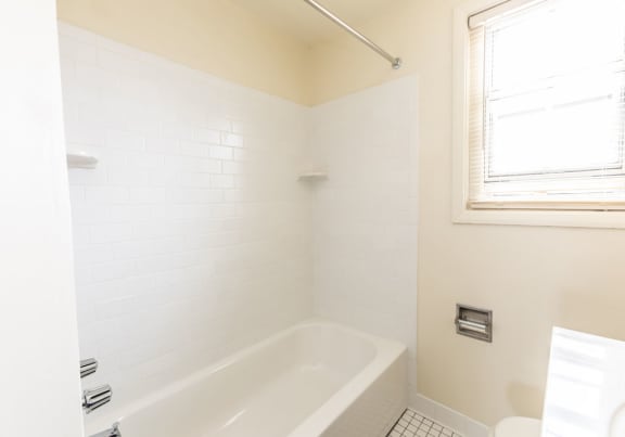 Bathroom with a white bathtub and a window at Foxridge Townhomes, Baltimore