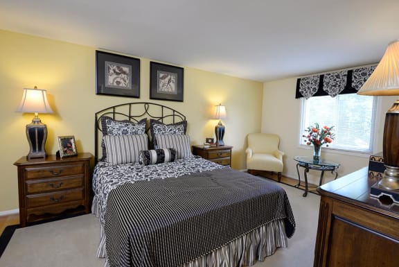 a bedroom with a bed and a chair and a table at Windsor House Apartments*, Maryland