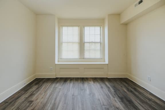 an empty room with hardwood floors and a large window at Ivy Hall Apartments*, Maryland