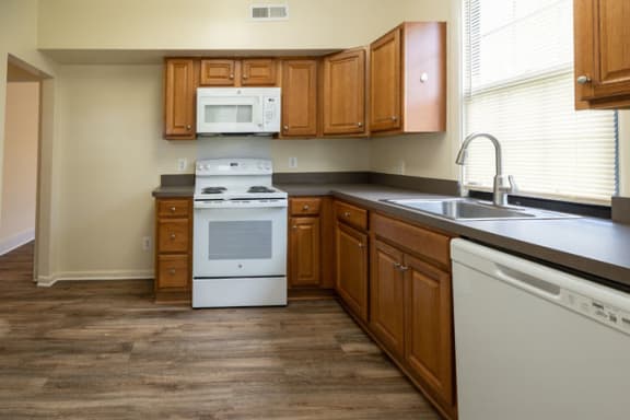 a kitchen with a white stove top oven next to a sink and a dishwasher at Ivy Hall Apartments*, Maryland