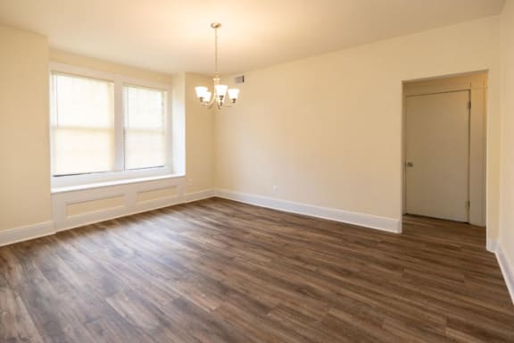 an empty living room with a chandelier at Ivy Hall Apartments*, Towson, MD 21204