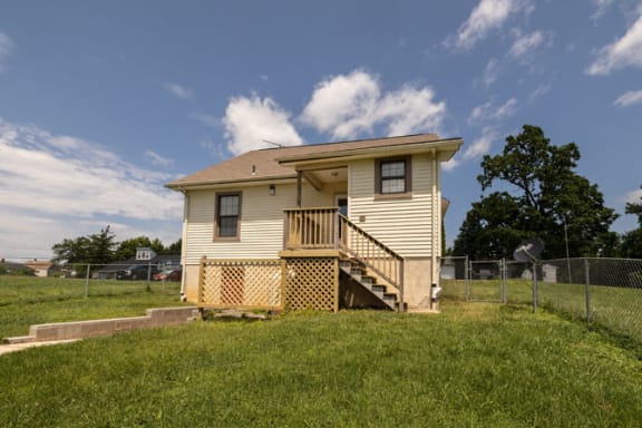 a house on a hill with a fenced in yard at Ivy Hall Apartments*, Towson
