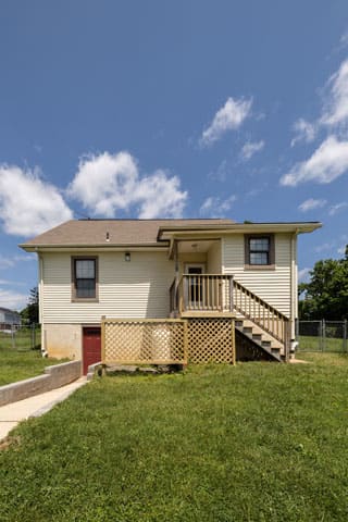a house with a porch and a lawn in front of it at Ivy Hall Apartments*, Maryland, 21204