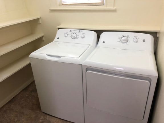 a washer and dryer sit side by side in a room with a window at Ivy Hall Apartments*, Towson