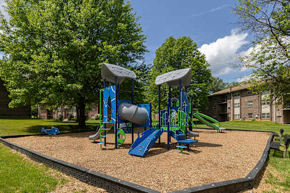 A playground with a blue slide and a green slide.at Deer Park Apartments, Randallstown Maryland
