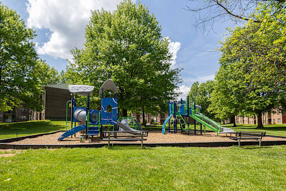 A playground with a blue slide and a green slide.at Deer Park Apartments, Randallstown, 21133