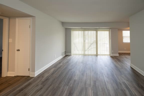 a bedroom with hardwood flooring and a door leading to a balcony