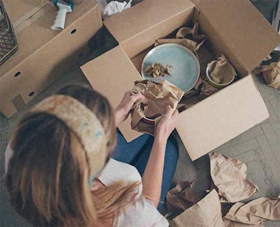 A woman is unpacking a box in a room.