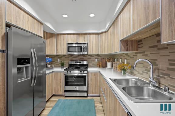 a kitchen with wood cabinets and stainless steel appliances