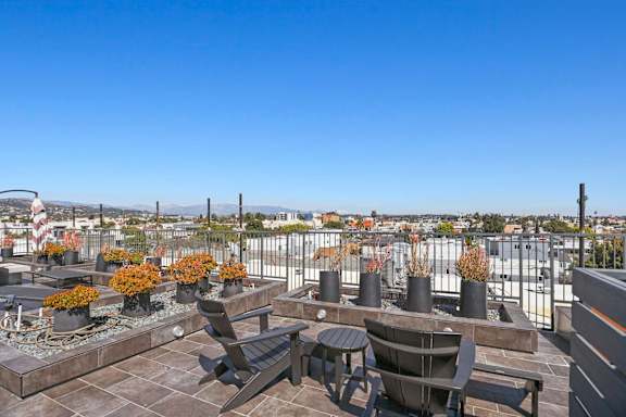 A patio with a table and chairs overlooking a cityscape.