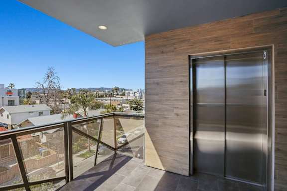 A modern house with a balcony and a view of the neighborhood.