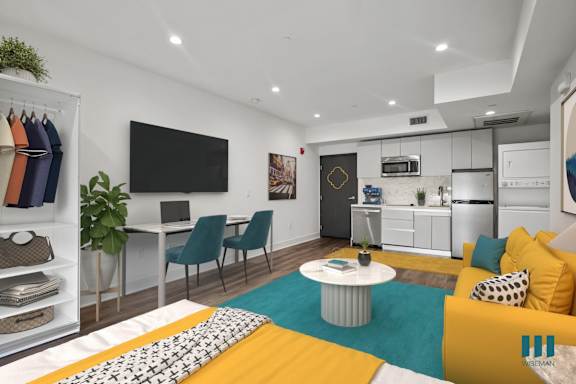 A living room with a yellow couch and a white coffee table.