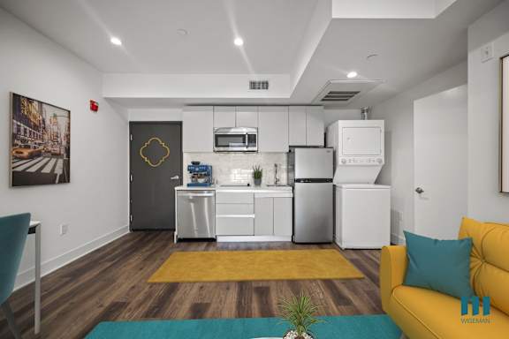 A kitchen with a yellow couch and a potted plant.